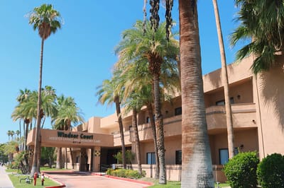 Exterior view of Windsor Court Assisted Living with palm trees