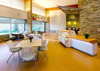 Bright and inviting dining area with tables and a dessert display.
