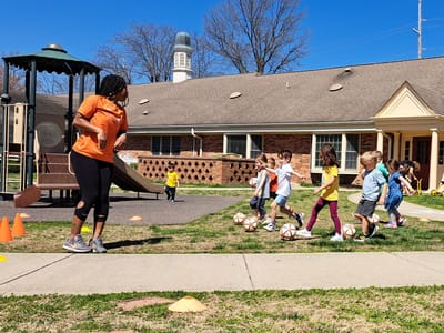 Children participating in a soccer practice outside.