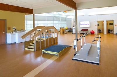 Rehabilitation area with exercise equipment and steps.
