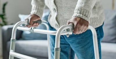 Person using a walker in a cozy indoor setting.