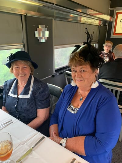 Two women dressed elegantly at a table.