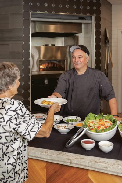 Chef serving a meal to a resident