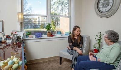 A caregiver talking with a resident in a cozy room