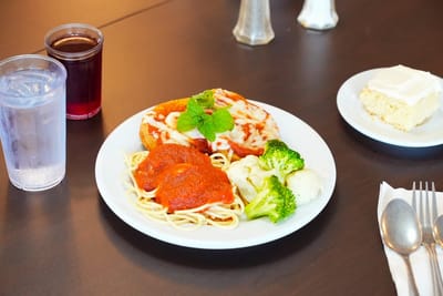 Plate of spaghetti with broccoli and dessert