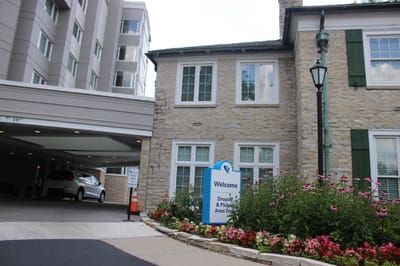 Exterior view of facility entrance with landscaping and sign