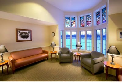 Bright common area with comfortable seating and stained glass windows