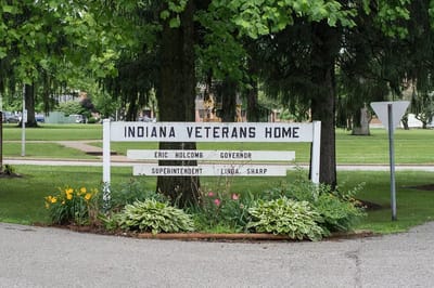 Sign for Indiana Veterans Home with flowers and trees
