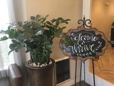 Welcome sign inside the facility next to a plant