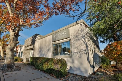 Exterior view of Redding Post Acute facility with autumn foliage