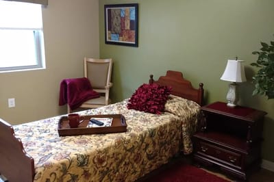 Cozy interior of a resident's bedroom with a bed and lamp