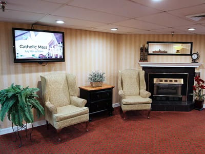 Cozy common area with chairs, fireplace, and TV