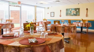Bright dining room setup with tables and floral decor