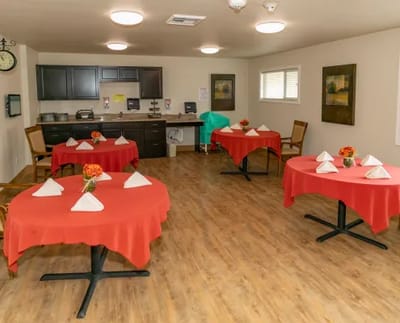 Dining area with red tablecloths and floral centerpieces