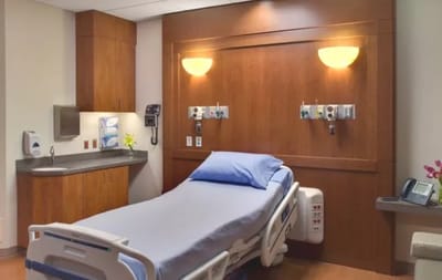 Hospital room with a bed and wooden cabinetry