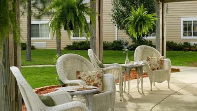 Outdoor seating area with wicker chairs and greenery