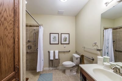 Brightly lit bathroom with shower and safety features