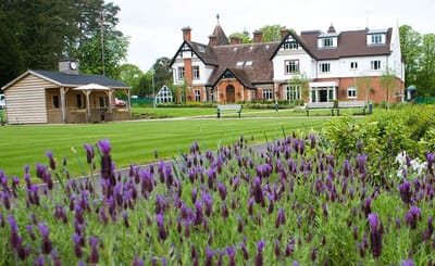 Exterior view of a nursing home with gardens and flowers