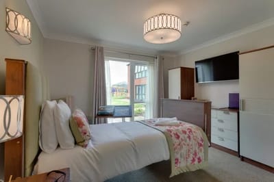 A well-furnished resident room with floral decor