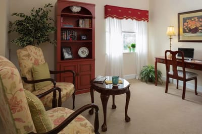 Cozy interior of a resident room with a desk and armchairs