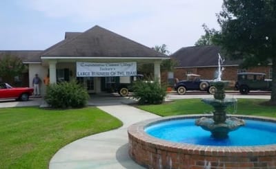Exterior view of Oakwood Village with a fountain and vintage cars