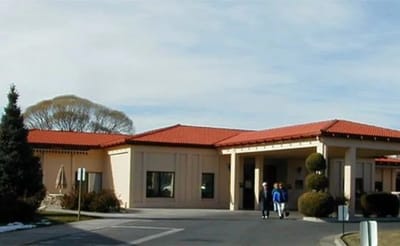 Exterior view of La Villa Grande Care Center with residents walking