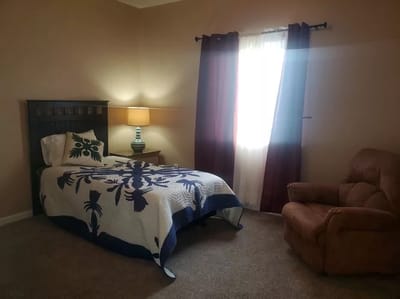 Cozy resident room with a bed and armchair