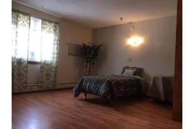 A well-lit resident room with a bed and decor