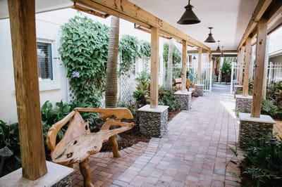 Outdoor walkway with wooden benches and greenery