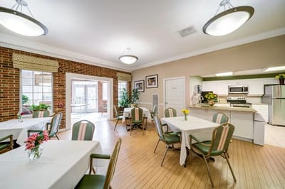 Bright common area with dining tables and kitchen visible