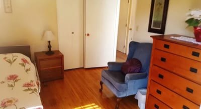Cozy bedroom with a bed, chair, and dresser