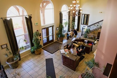 Interior view of a facility lobby with staff and plants