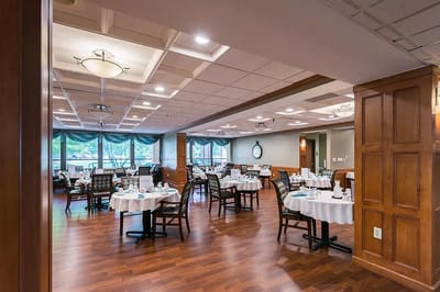Dining area with neatly set tables and wooden decor
