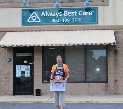 Person holding a box outside a senior care facility