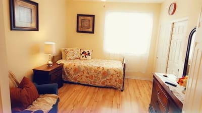 Cozy resident room with a bed and chair