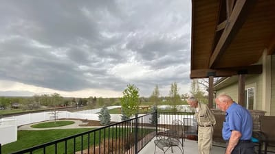 Two residents enjoying an outdoor space on a balcony