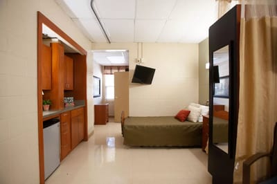 A well-furnished resident room with kitchenette