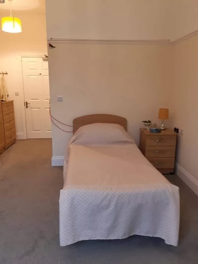Private room with a single bed and dresser