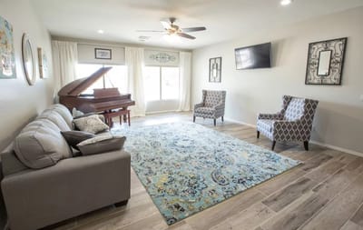 Bright common area with seating and a piano