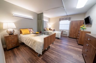 Cozy shared resident room with two beds and warm decor