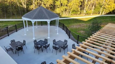 Outdoor gazebo and seating area surrounded by trees