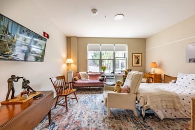 A cozy resident room with a bed and seating area