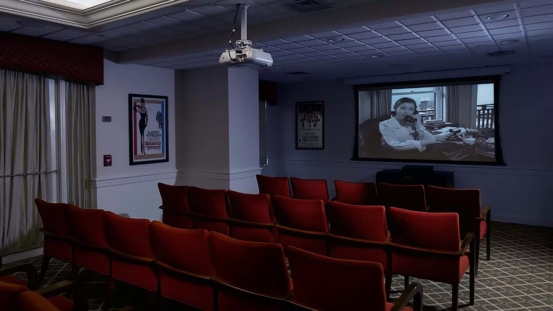 Auditorium with red chairs and a movie screen