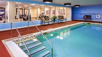 Indoor swimming pool with fitness equipment visible