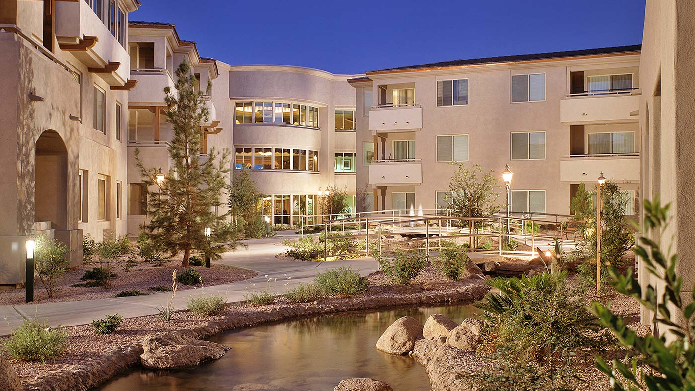 A serene outdoor courtyard with greenery and a stream