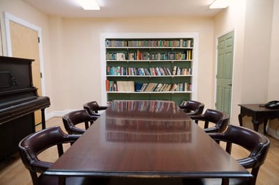 Meeting room with wooden table and bookshelves