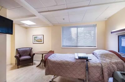 Private resident room with bed, chair, and television