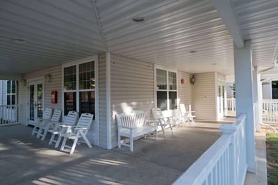Covered outdoor seating area with white chairs