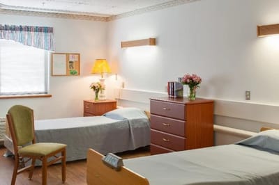 Cozy resident room with two beds and a lamp
