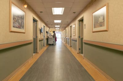 Narrow hallway in a nursing home with staff and residents